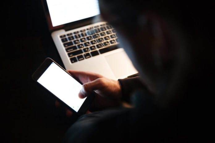 concentrated man using laptop computer phone 1013x675.jpg