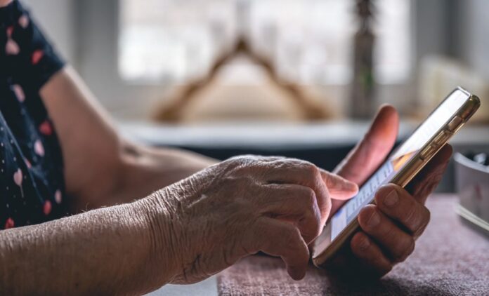 hands elderly woman holding mobile phone 1112x675.jpg